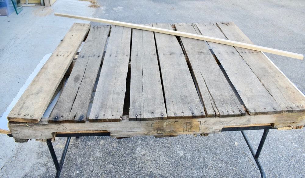 Use a straight board to mark cut lines for your pallet project - WildflowersAndWanderlust.com