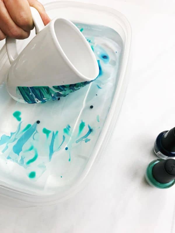 Dipping the mugs into the dye | WildflowersAndWanderlust.com